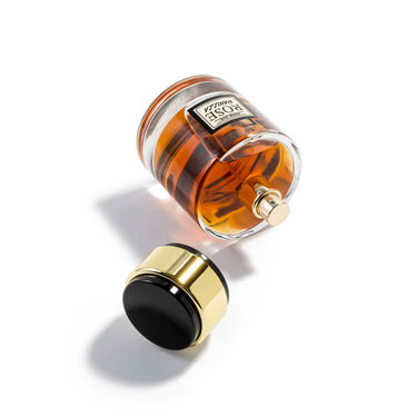 Perfume bottle with gold cap and black base on a white background